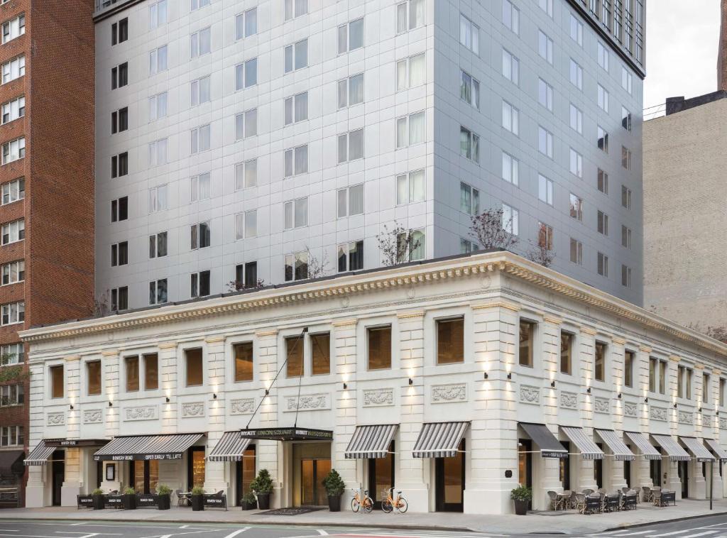 ein altes weißes Gebäude vor einem hohen Gebäude in der Unterkunft Hyatt Union Square New York in New York