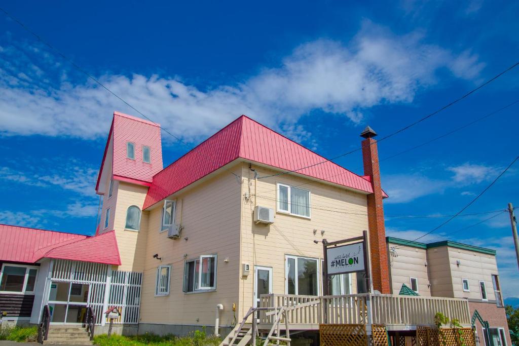 a large house with a red roof at petit hotel MELON Furano in Furano