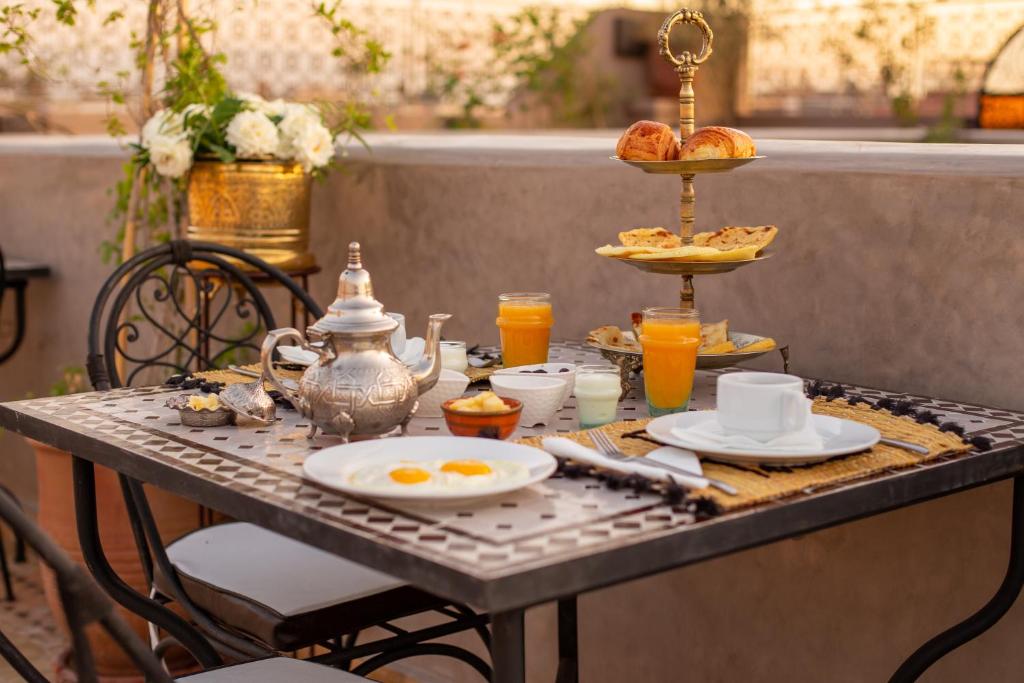 - une table avec petit-déjeuner composé d'œufs et de jus d'orange dans l'établissement Riad Touda, à Marrakech