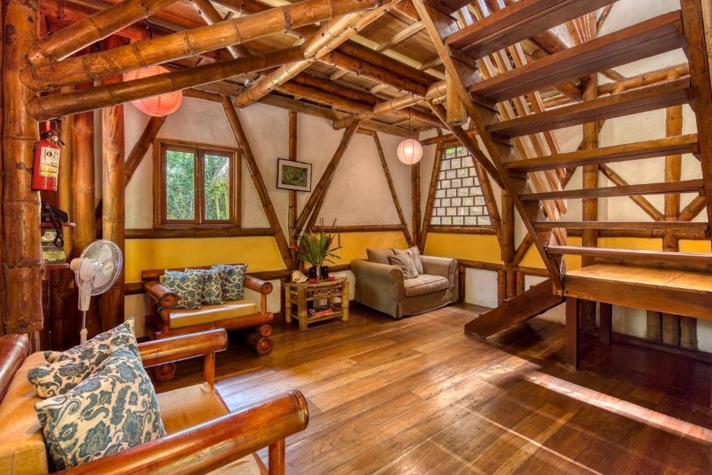 a large living room with wooden floors and wooden beams at Tree House Beachfront Lodge in Puerto Viejo