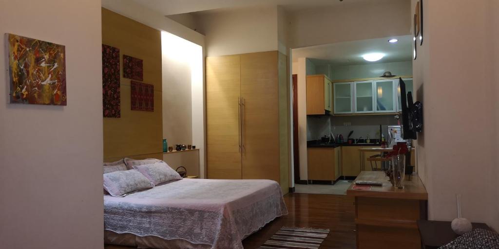 1 dormitorio pequeño con 1 cama y cocina en The Heritage Residence, en Seri Kembangan