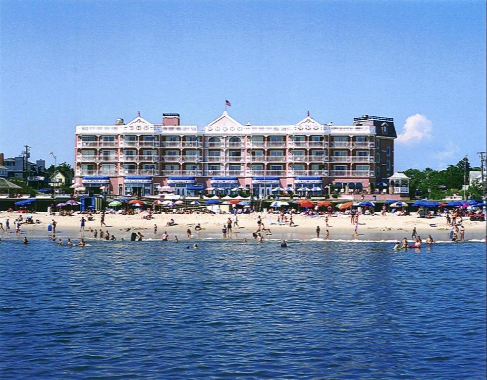 a group of people on the beach in front of a hotel at Boardwalk Plaza Hotel in Rehoboth Beach