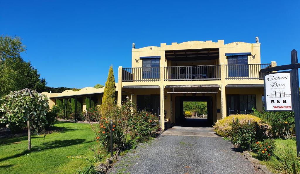 a large yellow building with a garage and a sign at Chateau Bass in Bass