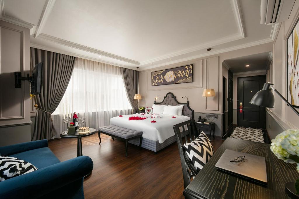 a hotel room with a bed and a dining room at Imperial Hotel & Spa in Hanoi