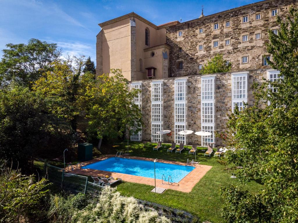 a large building with a swimming pool in front of it at Parador de Monforte de Lemos in Monforte de Lemos