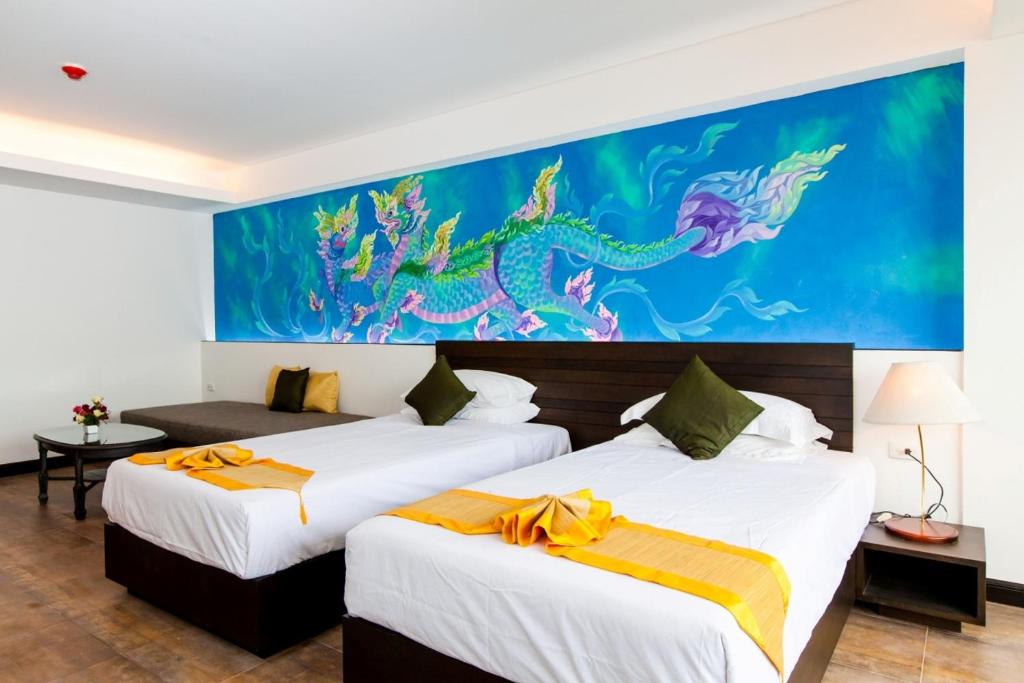 two beds in a hotel room with a painting on the wall at The Grand Sathorn in Bangkok