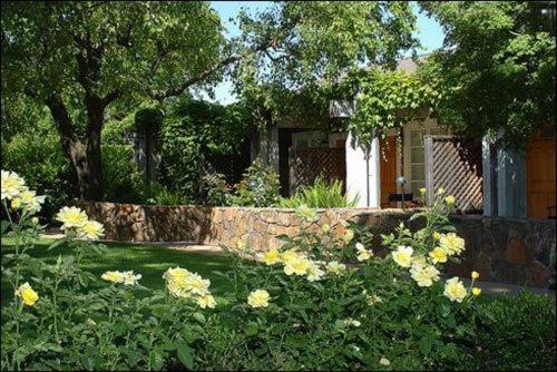 um jardim com flores amarelas em frente a uma casa em Petit Logis Inn em Yountville