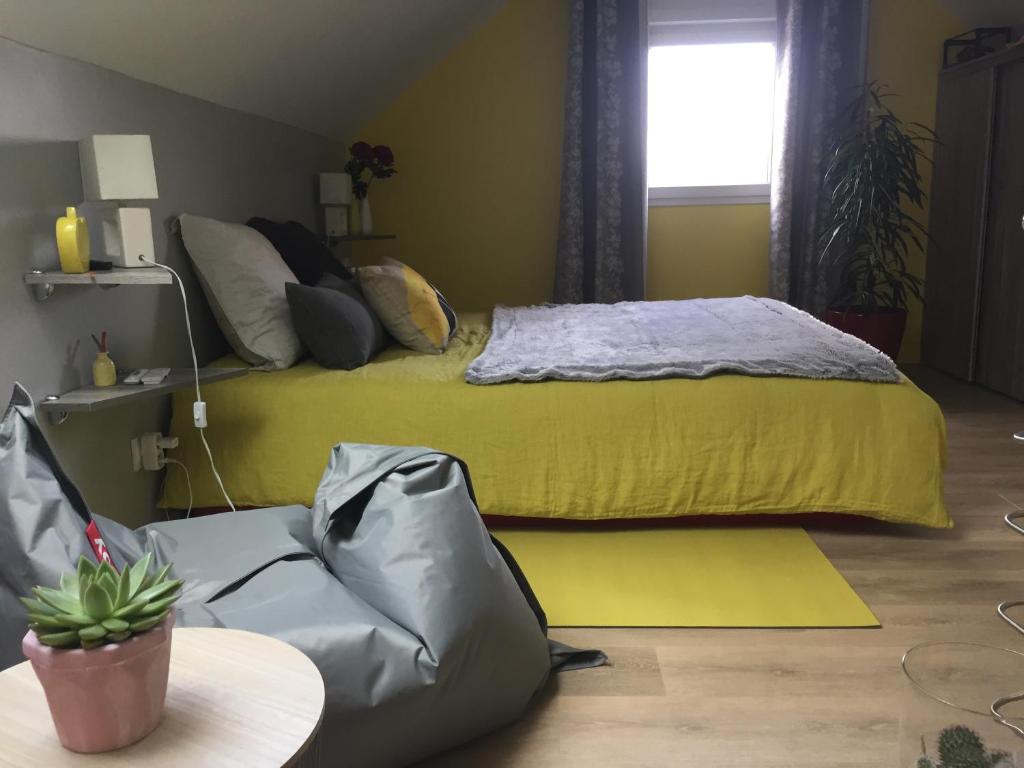 1 dormitorio con 1 cama con manta amarilla en Maison à la Campagne à 2km du Circuit de Bresse, en Sagy