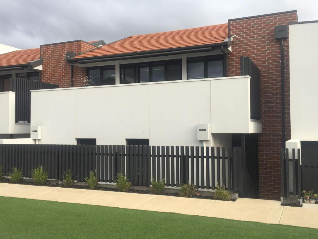 a house with a black and white fence at Central apartment with stairs in Ballarat