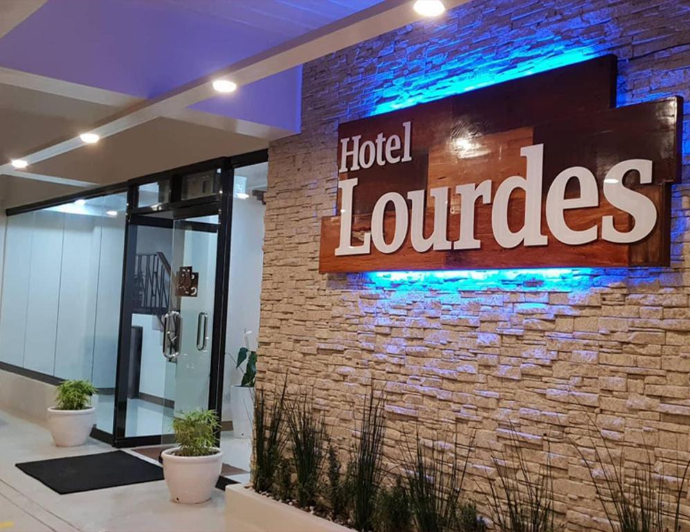 a hotel lobby with a sign on a brick wall at Hotel Lourdes in Laoag