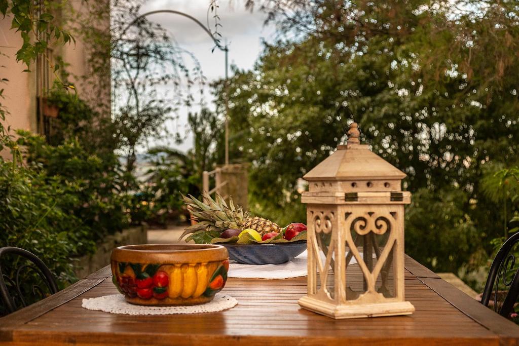 einen Holztisch mit einer Schale Obst und einer Schale Ananas in der Unterkunft Villa Maria Affittacamere in Canicattini Bagni