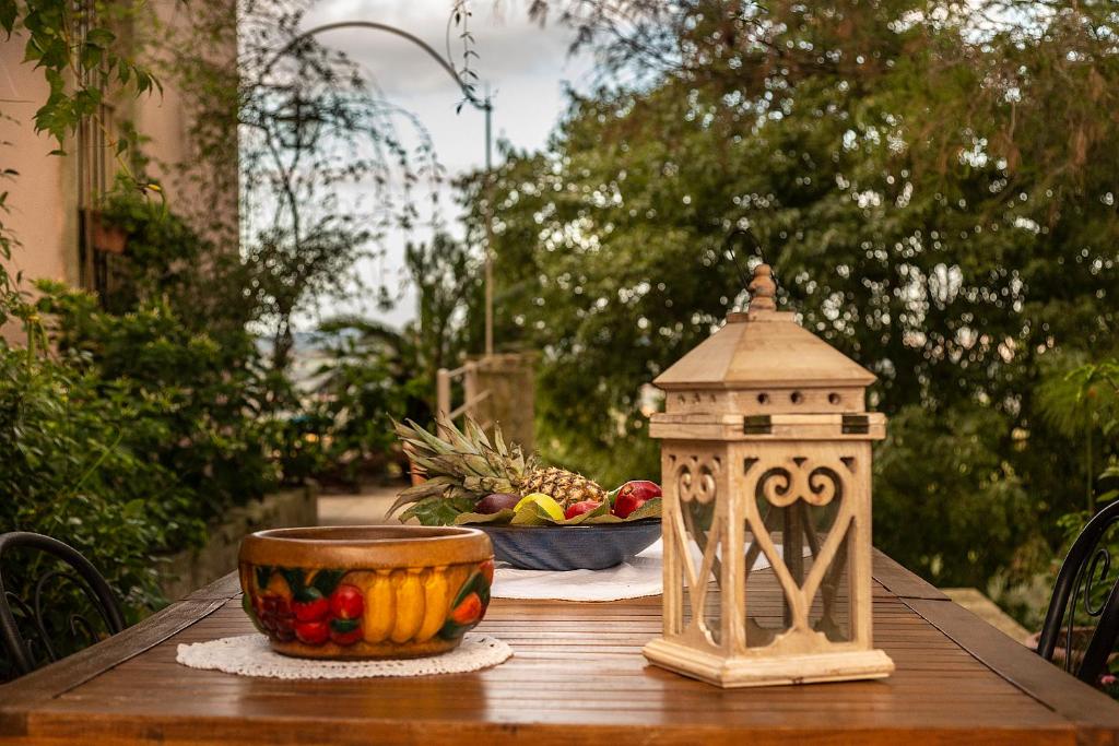 a wooden table with a bowl of fruit and a bowl of pineapple at Villa Maria Affittacamere in Canicattini Bagni
