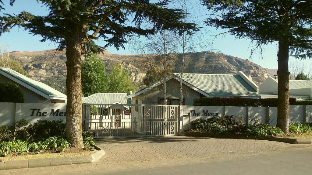 a white house with a gate and a mountain at 2 The Mews - easy walk to town and the CVC in Clarens