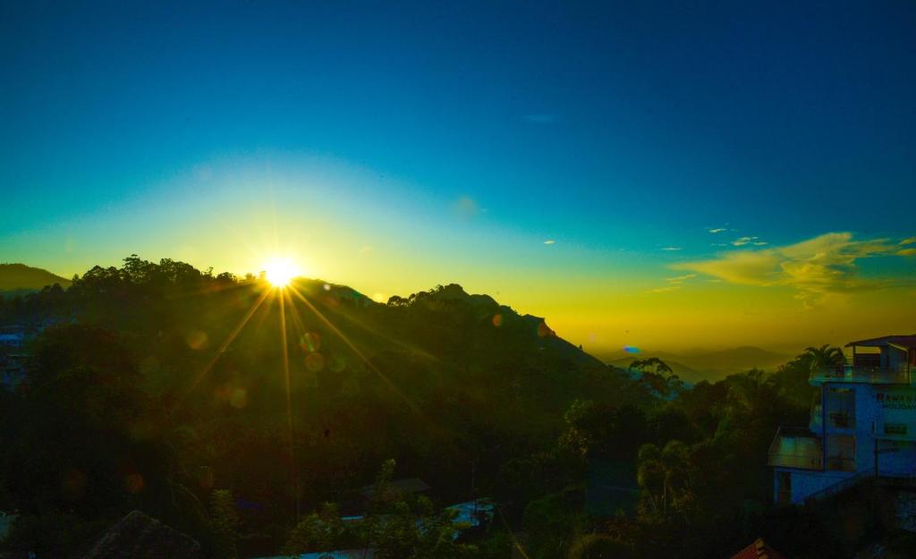 a sunset on top of a mountain with the sun setting at Senasuma Homestay in Ella