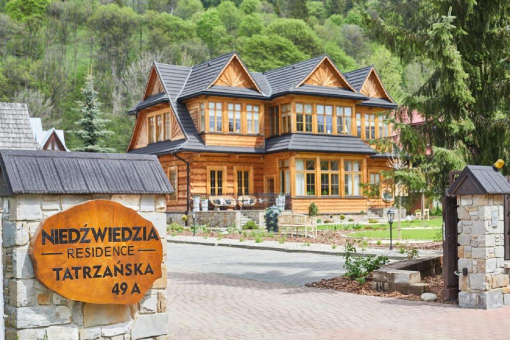 a house with a sign on the side of it at Niedźwiedzia Residence in Poronin