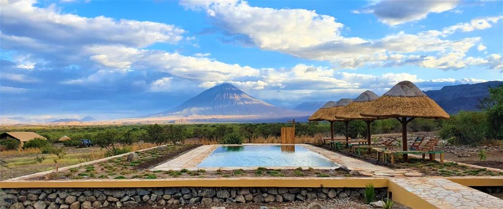 a mountain in the distance with a swimming pool and a view at Africa Safari Lake Natron in Mtowabaga
