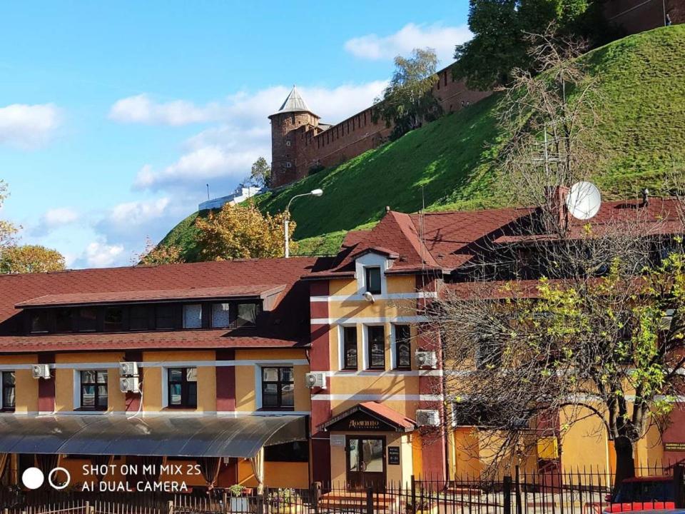 a building in front of a hill with a castle at Domino Hotel in Nizhny Novgorod