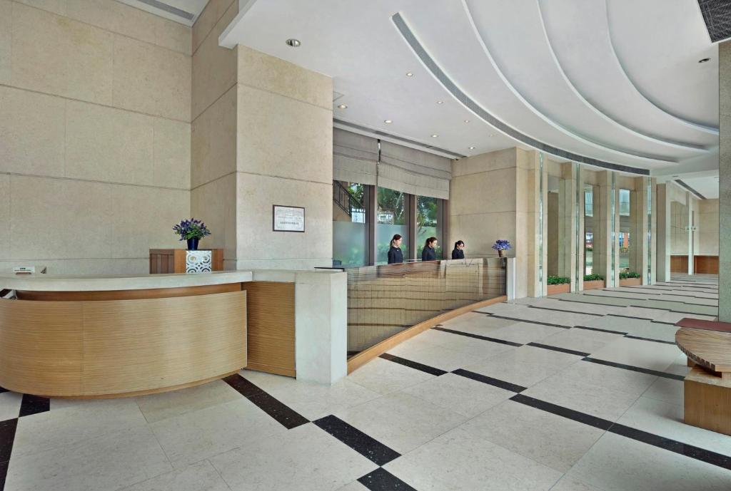 a lobby of a building with people standing in the windows at Rambler Oasis Hotel in Hong Kong