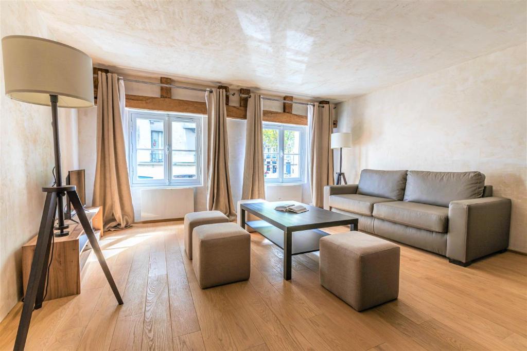 a living room with a couch and a table at Luxurious & Design Flat 2BR/8P- Boulevard Saint Germain in Paris