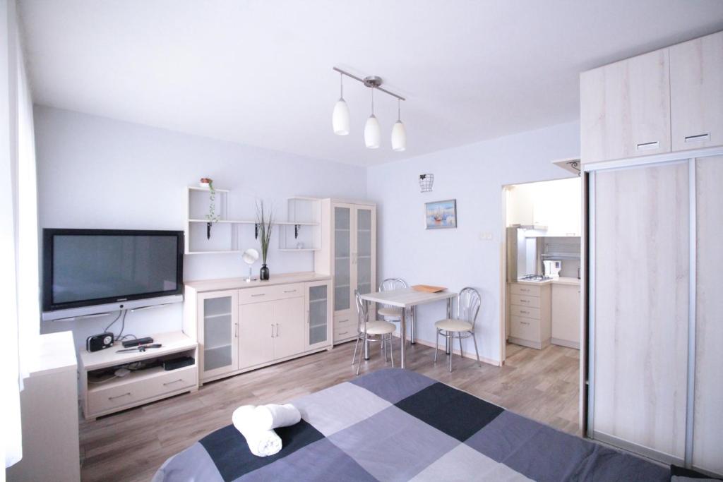 a white room with a bed and a table and a television at 01 Gdynia Centrum - Apartament Mieszkanie dla 2 os in Gdynia