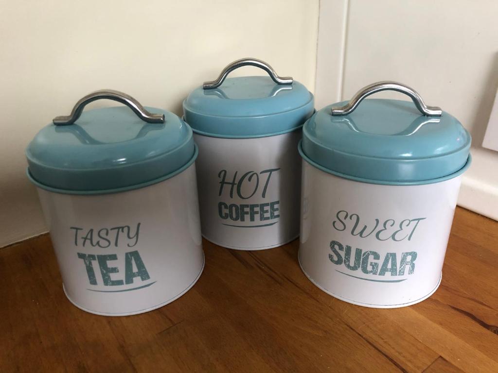 three coffee buckets with blue tops sitting on a floor at Sandford House Apartment in Seaford