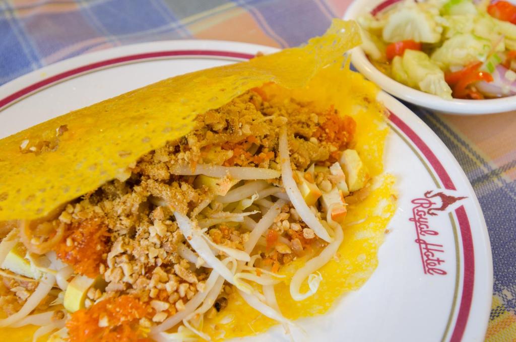 A close-up plate of a folded taco-style dish with a side salad.