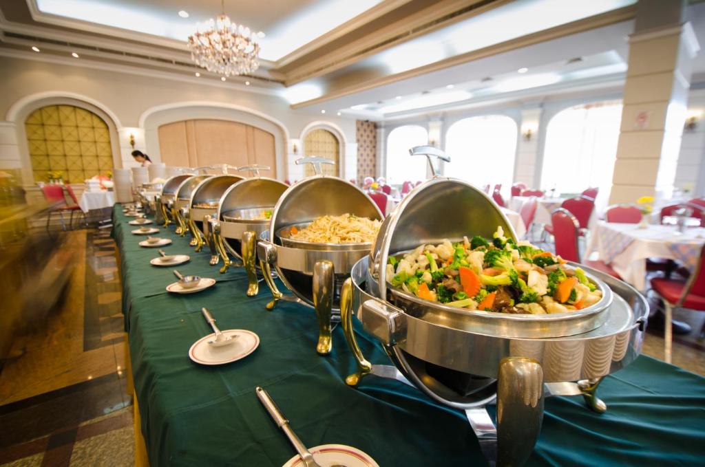 A buffet line displays covered hot dishes in a bright dining room.
