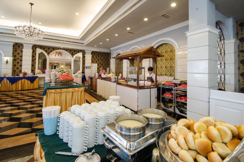 A breakfast buffet includes bread, cups, hot dishes, and a staffed service counter.