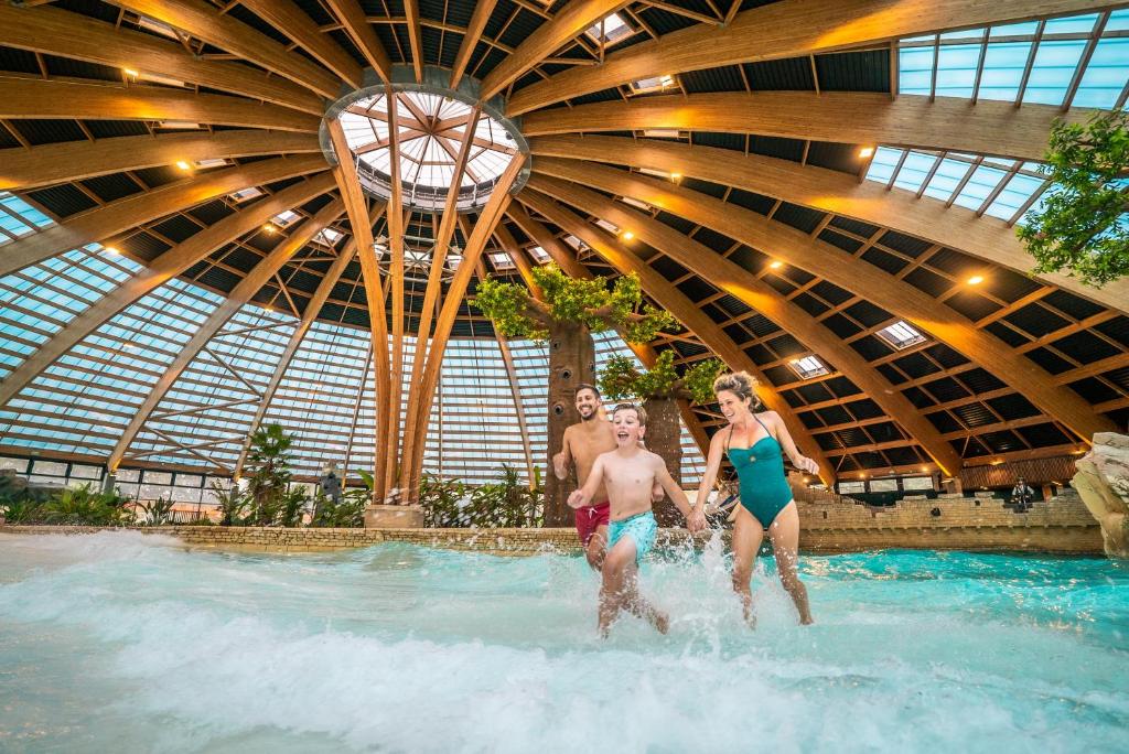 een groep mensen in een zwembad bij Les Ormes Domaine et Resort in Epiniac