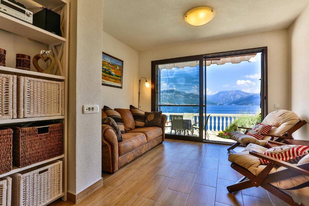 a living room with a couch and a large window at Apartment 365 in Tivat