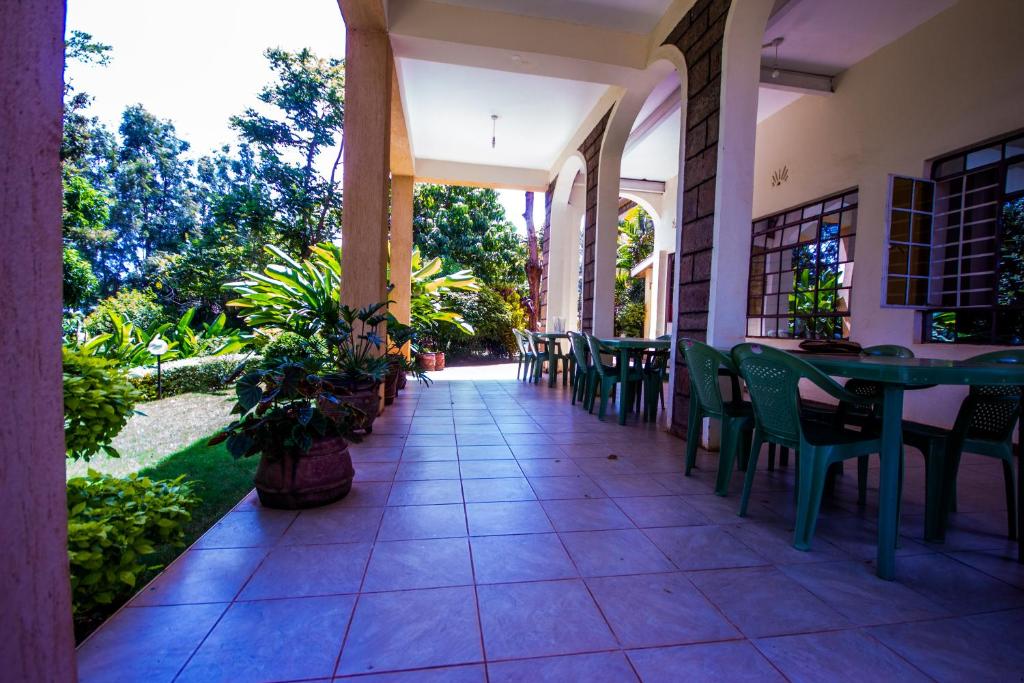 an outdoor patio with tables and chairs and plants at Riverfront Gardens in Mjini