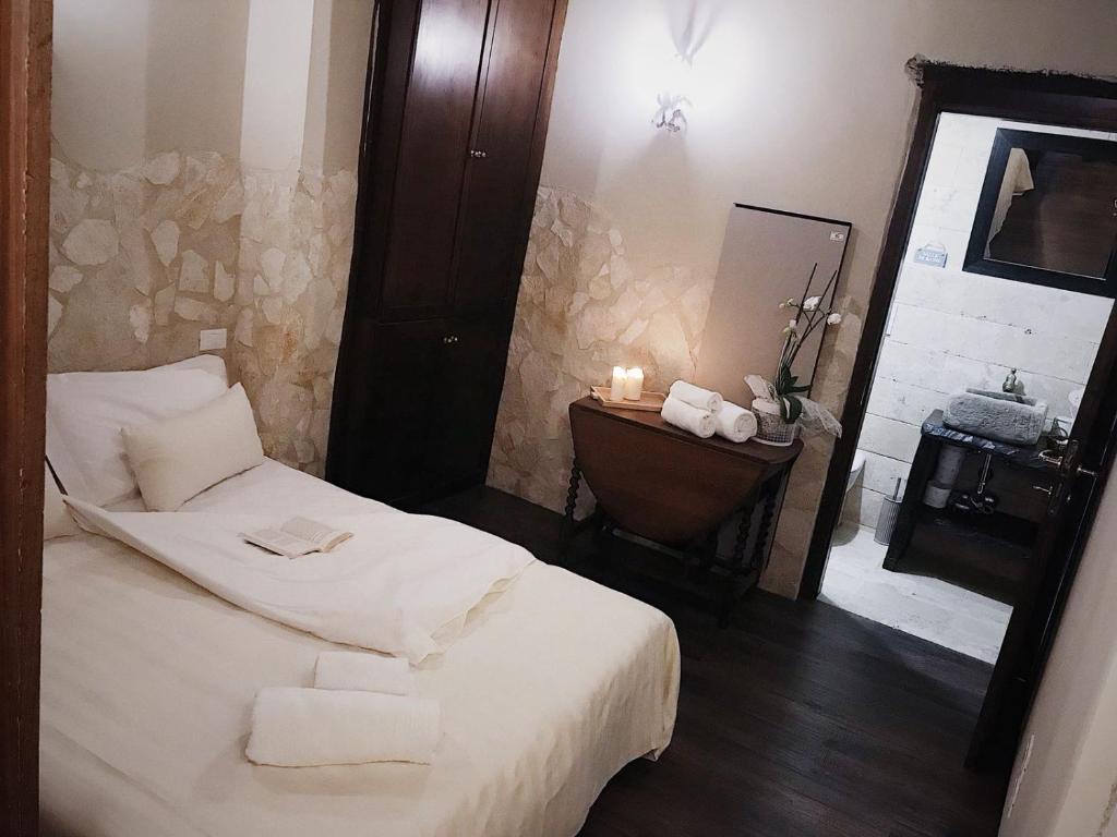 een slaapkamer met een wit bed en een spiegel bij Angolo Dei Priori - city center- in Perugia