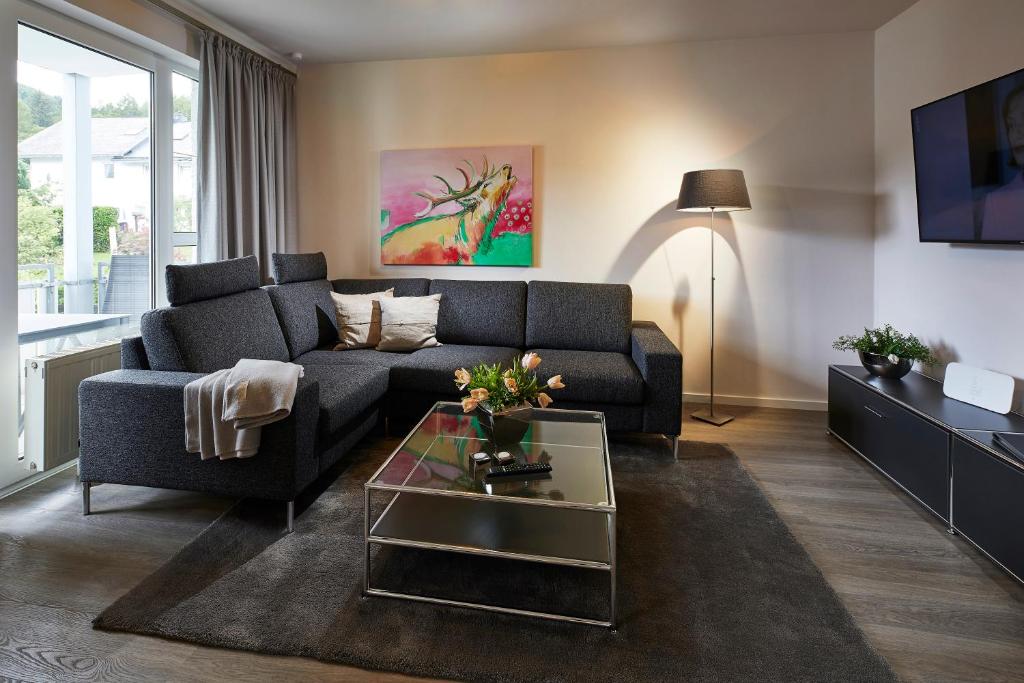 uma sala de estar com um sofá e uma mesa em Luxus Ferienwohnung Mein kleines Edelweiss em Willingen