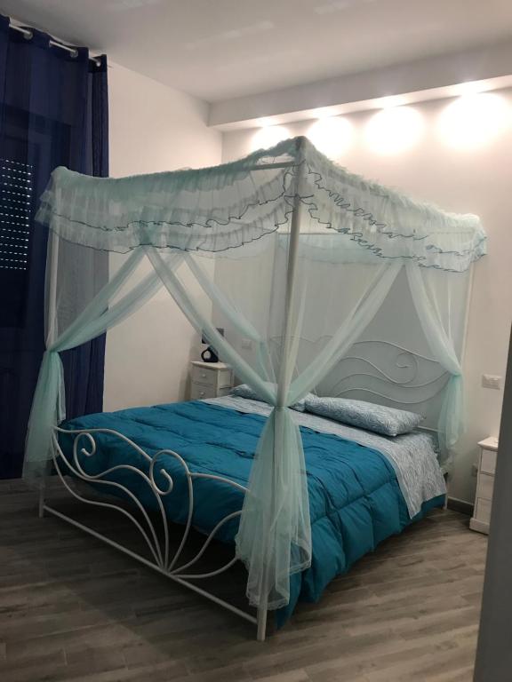 een slaapkamer met een hemelbed met blauwe lakens bij LunaBlù Cinecitta' in Rome