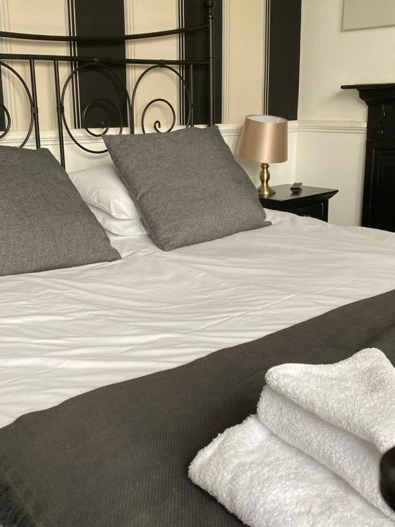 a bed with white sheets and pillows on it at The Red Lion Inn in Rothwell