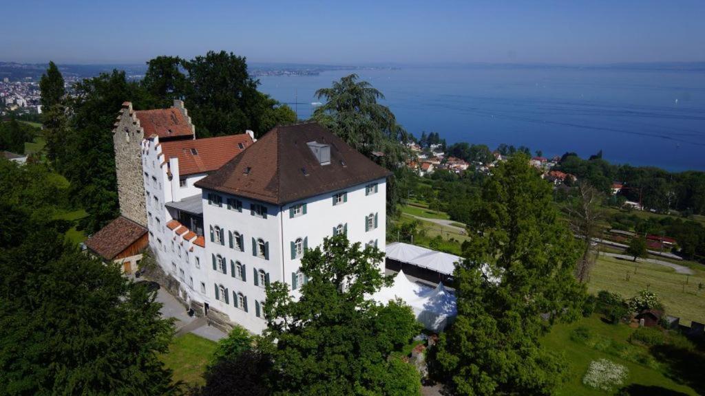 eine Luftansicht eines großen weißen Gebäudes mit braunem Dach in der Unterkunft Schloss Wartensee in Rorschacherberg