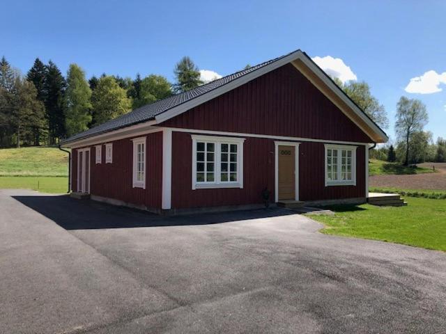 eine rote Scheune mit einer Einfahrt davor in der Unterkunft Ollestad gård in Ljung
