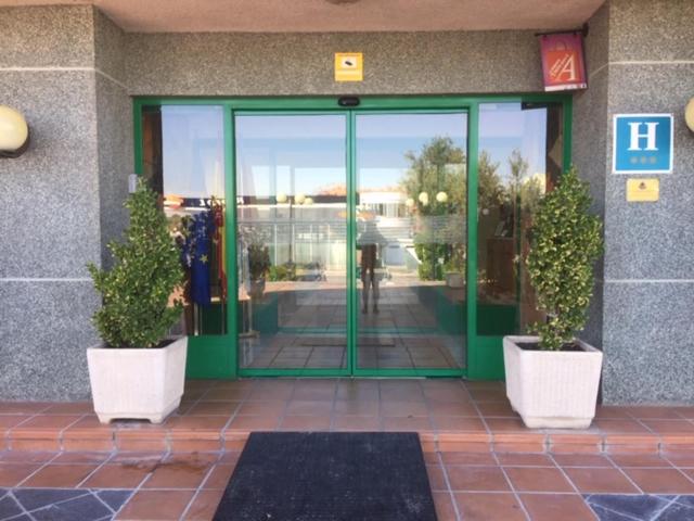 una entrada a un edificio con dos macetas delante en Miralcampo, en Azuqueca de Henares
