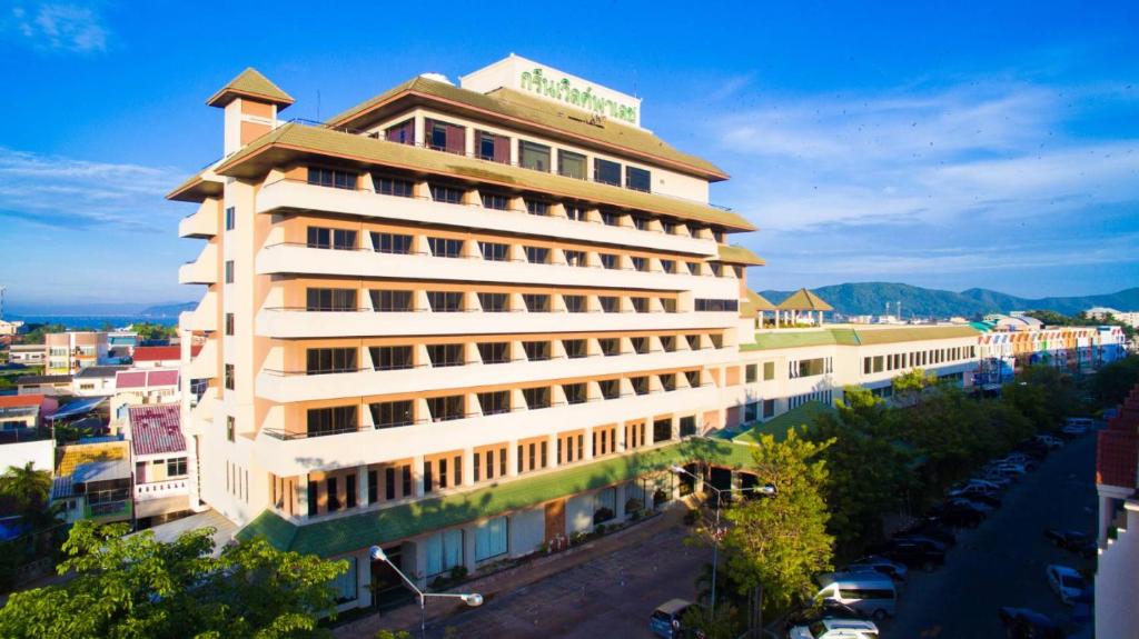 a large white building next to a river at Green World Palace Hotel in Songkhla