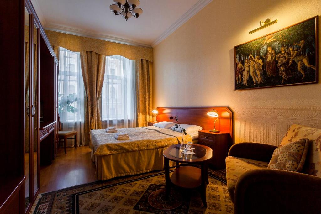 a hotel room with two beds and a couch at Baskov in Saint Petersburg