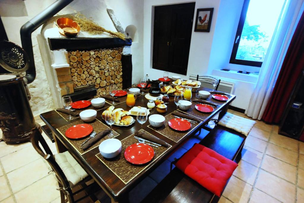 una mesa con platos rojos de comida. en Au dessus de Parady en Gillonnay