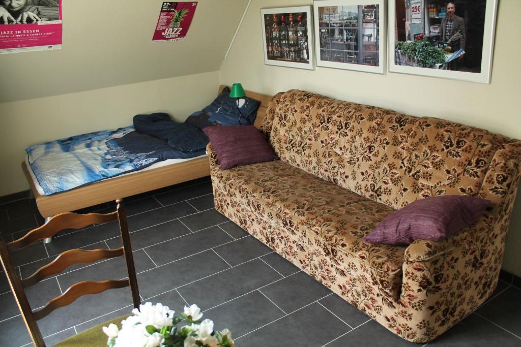 ein Wohnzimmer mit einem Sofa und einem Bett in der Unterkunft Gästezimmer 10 min von der Altstadt entfernt in Hattingen