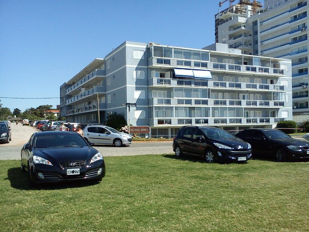 un groupe de voitures garées devant un bâtiment dans l'établissement Monoambiente Parada 5 Playa Brava - Punta del Este, à Punta del Este