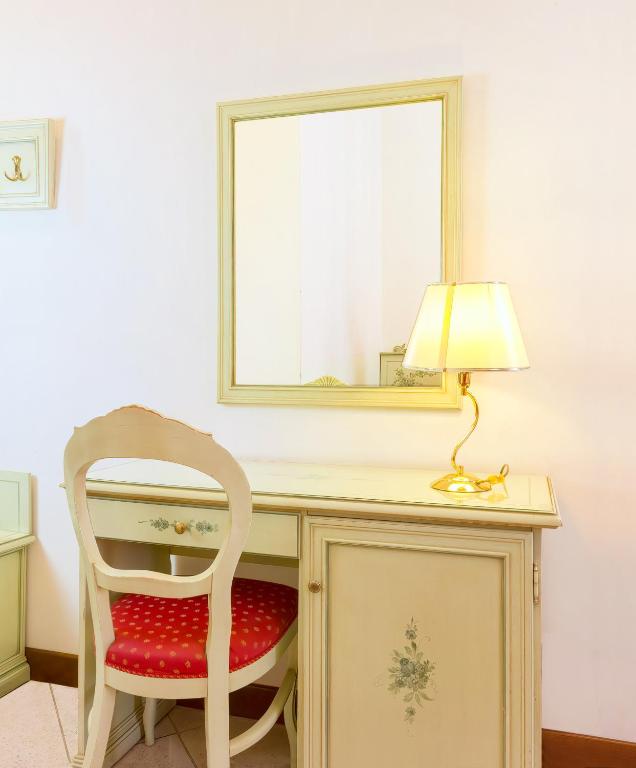 a desk with a chair and a lamp and a mirror at Guesthouse Ca&#39; San Marcuola 1 in Venice