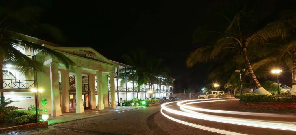 eine Straße in der Nacht mit Palmen und einem Gebäude in der Unterkunft Best Western Plus Accra Beach Hotel in Teshi