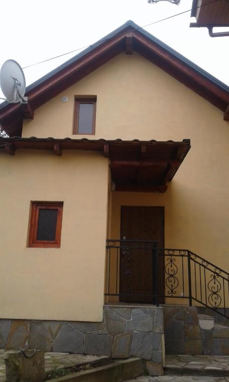 une maison avec un portail et un balcon dans l'établissement Dva Opryshka, à Yaremtche