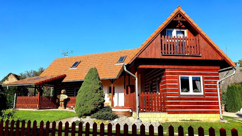 a red house with a fence in front of it at Roubenka Rozkoš in Nové Město nad Metují