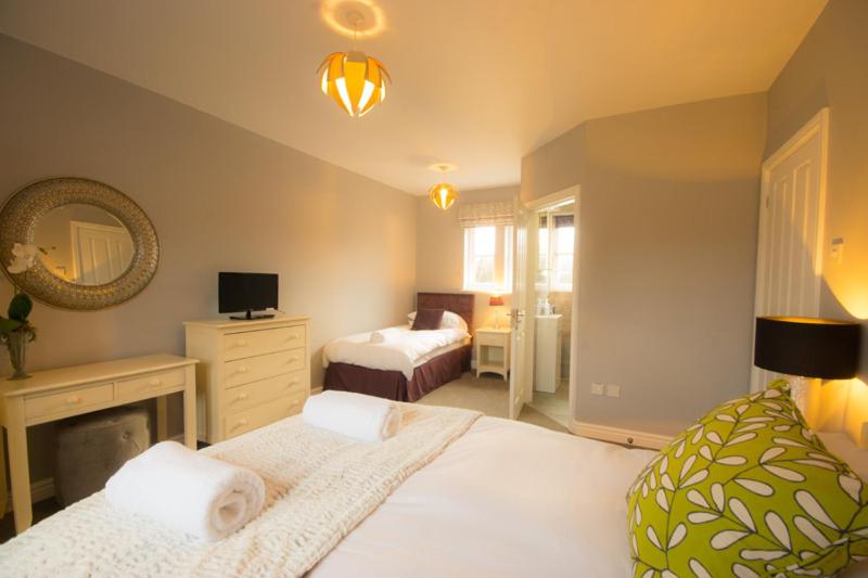 a bedroom with two beds and a fireplace in it at Riber Cottage - Darwin Lake Holiday Village in Matlock