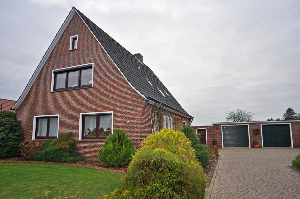 una casa de ladrillo rojo con techo negro en Ferienwohnung An der Wieke, 65295, en Moormerland