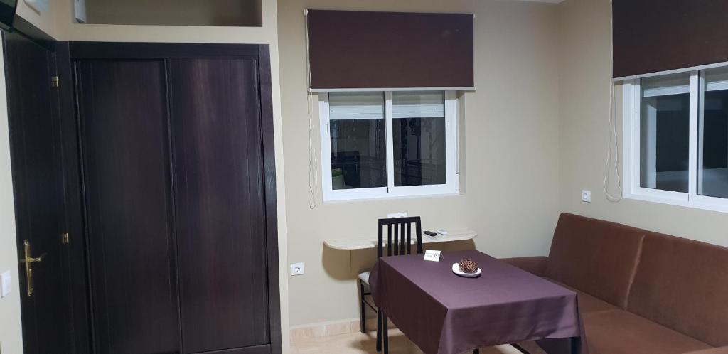 a living room with a table and a couch at Hostal Málaga in Arcos de la Frontera